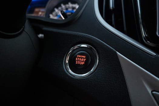 Close-up image of a car's engine start stop button on the dashboard.